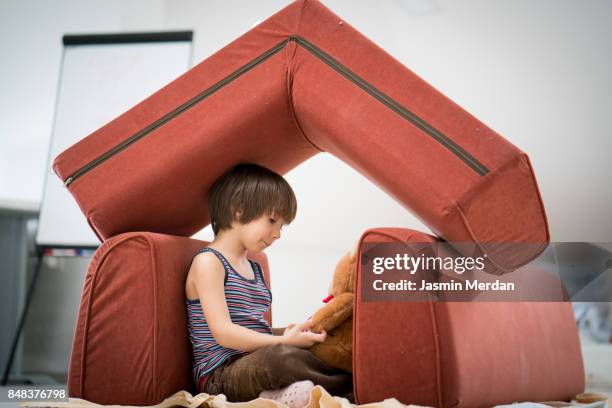 little boy and teddy bear with small house made of furniture - home security stock pictures, royalty-free photos & images