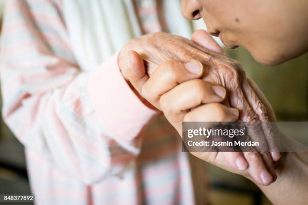 muslim woman kissing hand of her old mother - kisses the hand stock pictures, royalty-free photos & images