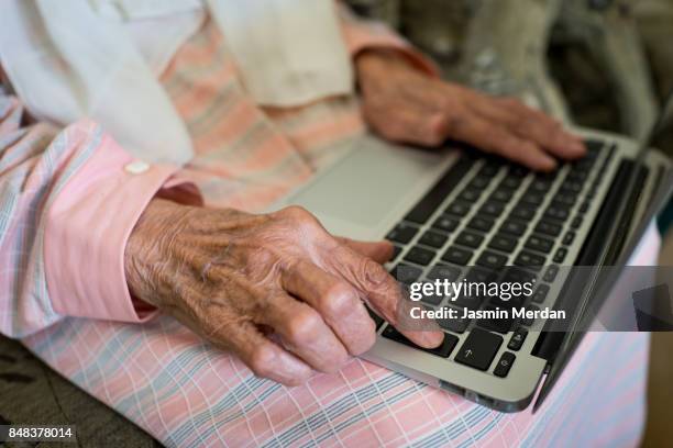 very old woman using laptop at home - arabic people ストックフォトと画像