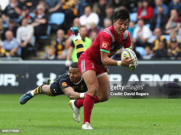 Marcus Smith of Harlequins is tackled by Marcus Waton during the Aviva Premiership match between Wasps and Harlequins at The Ricoh Arena on September...