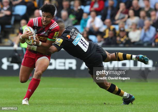 Marcus Smith of Harlequins is tackled by Marcus Waton during the Aviva Premiership match between Wasps and Harlequins at The Ricoh Arena on September...