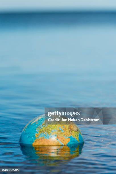 globe floating on water - politica e governo foto e immagini stock