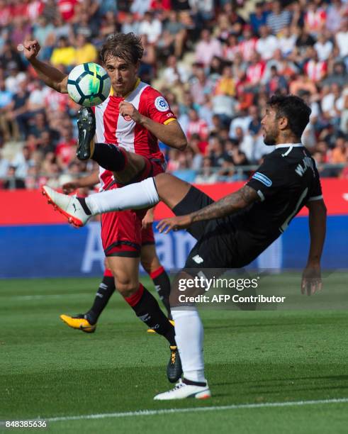 Girona's defender Marc Muniesa vies with Sevilla's Argentinian midfielder Walter Montoya during the Spanish league football match Girona FC vs...