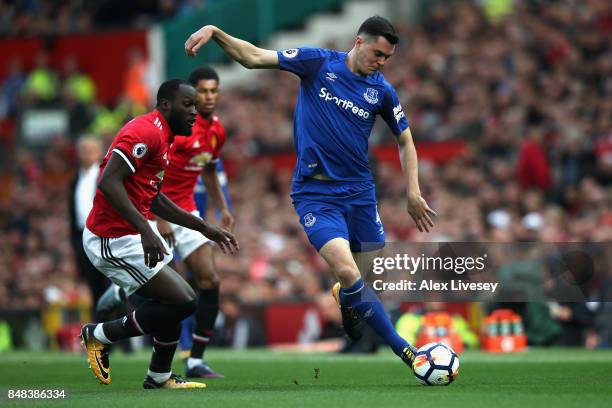 Michael Keane of Everton shoots while under pressure from Romelu Lukaku of Manchester United during the Premier League match between Manchester...