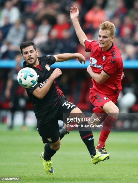 Kevin Volland of Leverkusen is challenged by Philipp Lienhart of Freiburg during the Bundesliga match between Bayer 04 Leverkusen and SC Freiburg at...
