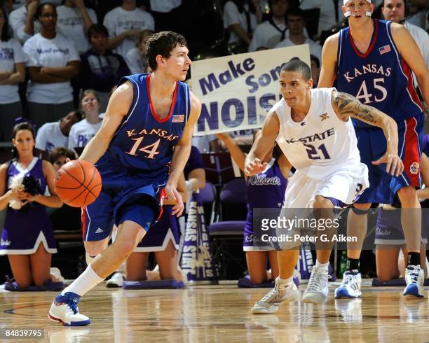 Tyrel Reed of the Kansas Jayhawks drives around pressure from Denis Clemente of the Kansas State Wildcats on February 14, 2009 at Bramlage Coliseum...
