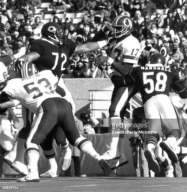 Chicago Bears defensive tackle William "The Refrigerator" Perry gives Redskins quarterback Doug Williams a shove in the schnoz during the Bears 21-17...