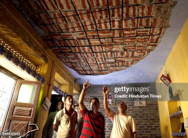 Villagers show the damaged roof of their house after a heavy mortar shelling by Pakistan Rangers on Saturday night, at Arnia village, on September...