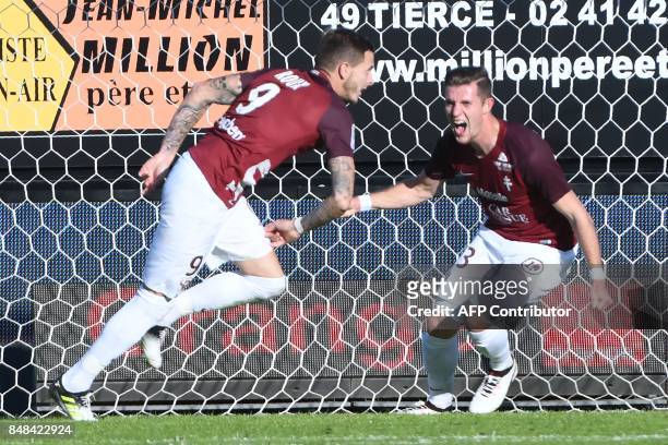 Metz's French forward Nolan Roux is congratulated by Metz's Luxemburg defender Chris Philipps after scoring Angers' French goalkeeper Alexandre...