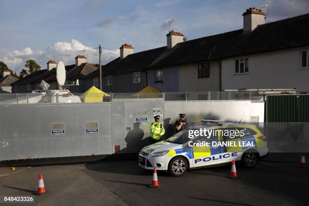 Police stand guard alongside a police barrier during a search operation by a police forensics team of a house in Sunbury, Surrey near London on...