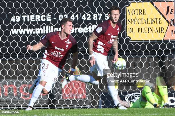Metz's French forward Nolan Roux is congratulated by Metz's Luxemburg defender Chris Philipps after scoring in spite of Angers' French goalkeeper...
