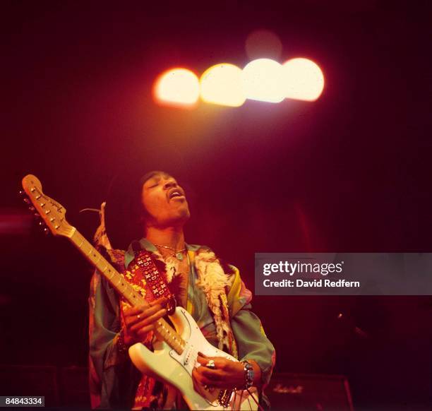 American rock guitarist and singer Jimi Hendrix performs live on stage playing a white Fender Stratocaster guitar with The Jimi Hendrix Experience at...