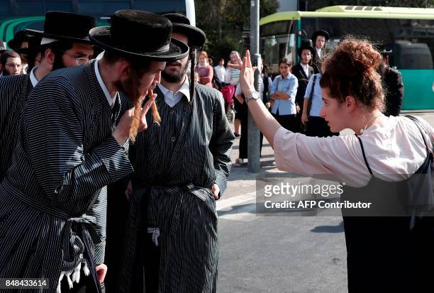 Woman gestures towards an ultra-Orthodox Jewish man taking part in a demonstration against a court ruling that could require them to serve in the...