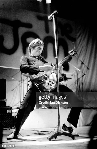 Photo of Paul WELLER and JAM; Premium Image! - Paul Weller performing live onstage, playing Rickenbacker 330 guitar, with The Jam logo on backdrop...