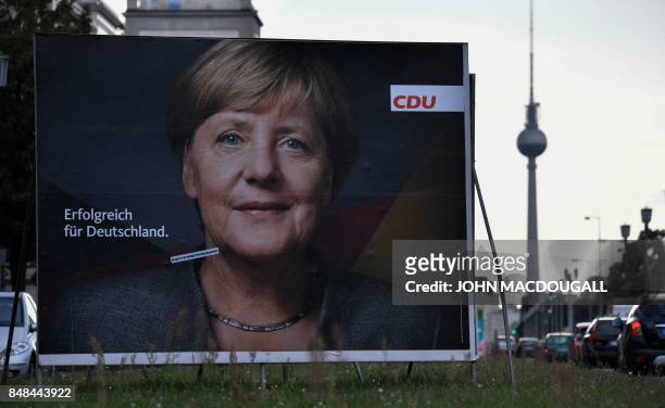 Billboard featuring German Chancellor and leader of the conservative Christian Democratic Union party Angela Merkel is pictured in front of the TV...