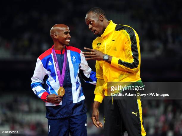 Great Britain Mo Farah with Usain Bolt with a gold medal after victory in the Men's 5000m final on day fifteen of the London Olympic Games in the...