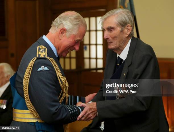 Prince Charles, Prince of Wales talks to Battle of Britain veteran Wing Commander Paul Farnes during a reception following a service marking the 77th...