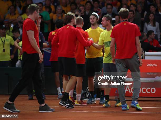 The Belgium team are congratulated by Captain Lleyton Hewitt of Australia after Steve Darcis of Belgium won the fifth rubber during day three of the...