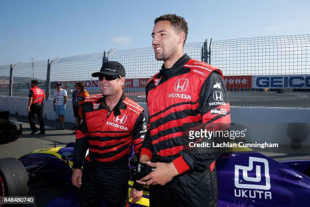 Klay Thompson of the Golden State Warriors NBA team meets driver Davey Hamilton after a ride in a two-seat IndyCar on day 3 of the GoPro Grand Prix...