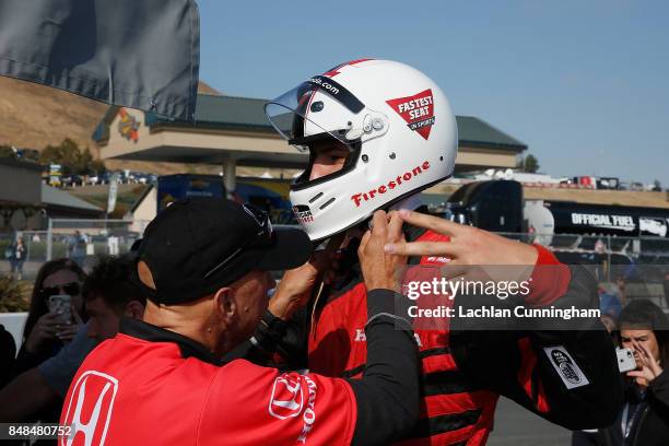 Klay Thompson of the Golden State Warriors NBA team suits up at the track for a ride in a two-seat IndyCar with driver Davey Hamilton on day 3 of the...