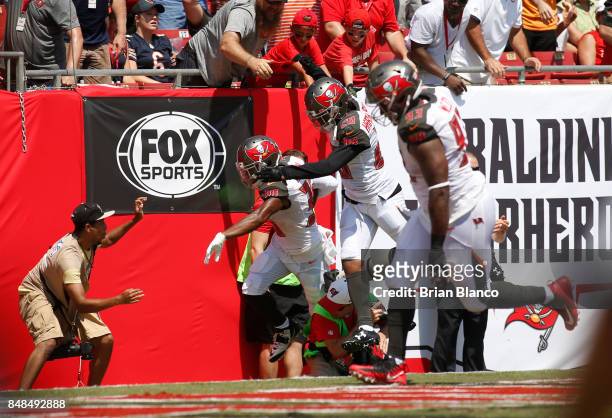 Defensive back Robert McClain of the Tampa Bay Buccaneers runs into the end zone followed by teammates cornerback Vernon Hargreaves and defensive...