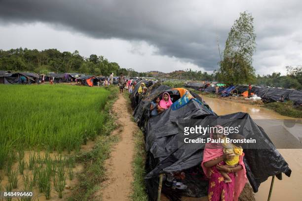 Refugees shelter along a stream as the monsoon rains create massive challenges for the displaced Rohingya September 17, 2017 in Kutupalong, Cox's...