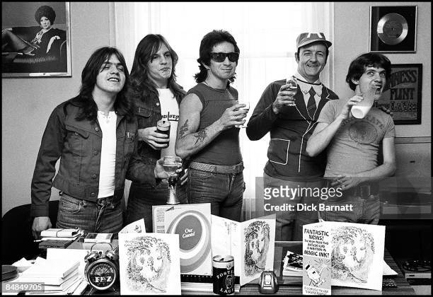 Photo of AC/DC; L-R: Malcolm Young, Mark Evans, Bon Scott, ? manager Michael Browning ?, Angus Young - posed, at press reception in WEA offices