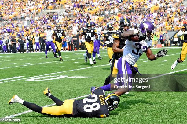 Dalvin Cook of the Minnesota Vikings is tripped up as he carries the ball by Sean Davis of the Pittsburgh Steelers in the third quarter during the...
