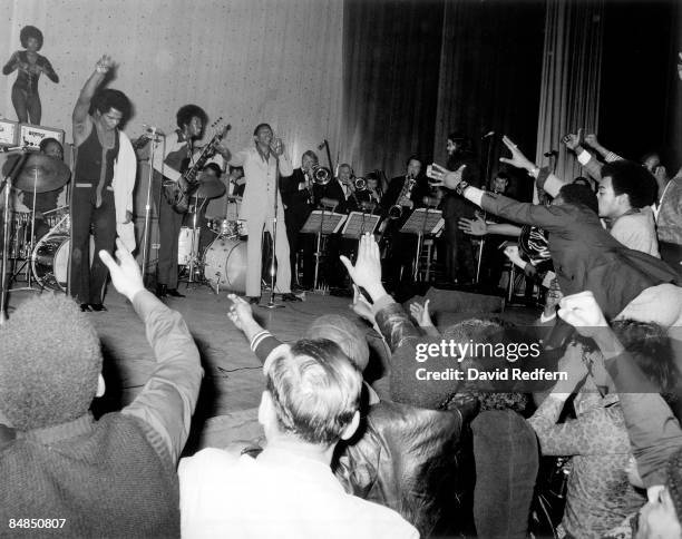 American soul singer and songwriter James Brown performs live on stage with the J.B.'s, including bass guitarist Bootsy Collins and singer Bobby Byrd...