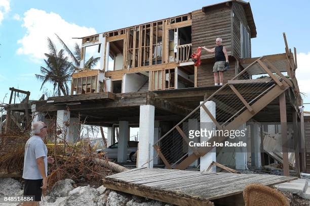John Rhode talks with his neighbor Paul Sosbey as he attempts to salvage what he can from his home that was destroyed by hurricane Irma on September...