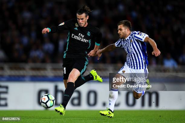 Gareth Bale of Real Madrid CF competes for the ball with Kevin Rodrigues of Real Sociedad de Futbol to score his team's third goal during the La Liga...