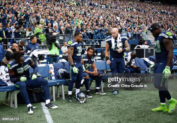 Defensive end Michael Bennett of the Seattle Seahawks, center, sitting, is joined by teammates defensive end Frank Clark, left, running back Thomas...