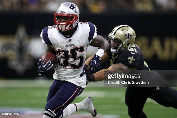 Mike Gillislee of the New England Patriots avoids a tackle by Trey Hendrickson of the New Orleans Saints at the Mercedes-Benz Superdome on September...