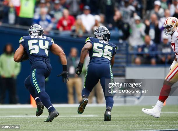 Middle linebacker Bobby Wagner of the Seattle Seahawks runs with defensive end Cliff Avril after intercepting quarterback Brian Hoyer of the San...