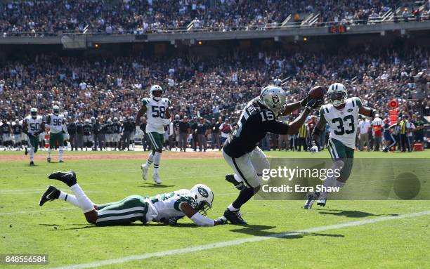 Michael Crabtree of the Oakland Raiders gets past Juston Burris and Jamal Adams of the New York Jets to score a touchdown at Oakland-Alameda County...