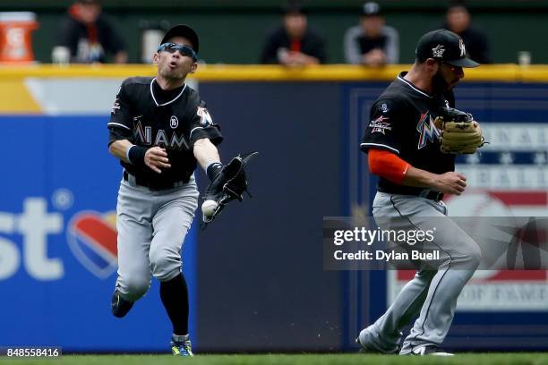 Ichiro Suzuki of the Miami Marlins fails to catch a fly ball in front of Mike Aviles in the fourth inning against the Milwaukee Brewers at Miller...