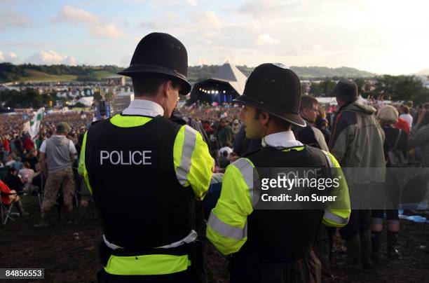 Photo of GLASTONBURY, two policemen at the Pyramid Stage at Glastonbury Festival with crowds in front, festivals, security