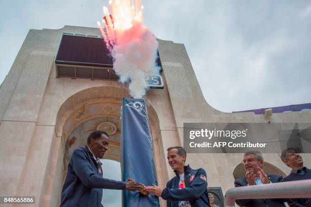 Olympic gold medalist Rafer Johnson , Los Angeles Mayor Eric Garcetti push the ignition switch to light the Los Angeles Memorial Coliseum's Olympic...