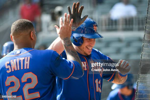 Asdrubal Cabrera of the New York Mets celebrates with Dominic Smith as he enters the dugout after hitting a two run home run against the Atlanta...