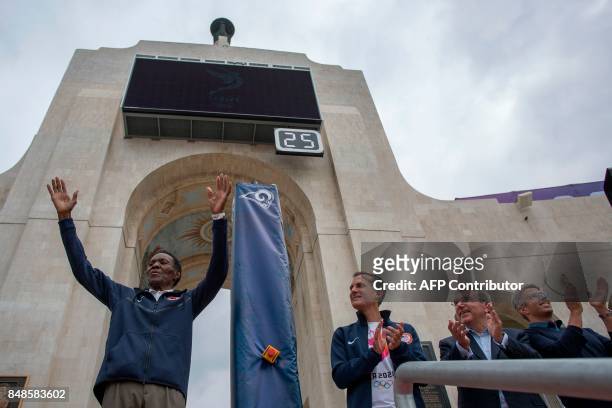 Olympic Gold Medalist Rafer Johnson acknowledges the crowd as Los Angeles Mayor Eric Garcetti, International Olympic Committee President Thomas Bach...