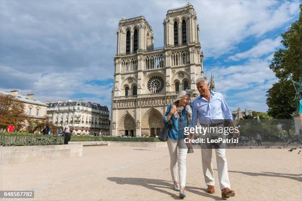 happy seniors in paris, having a wonderful vacation - notre dame de paris stock pictures, royalty-free photos & images