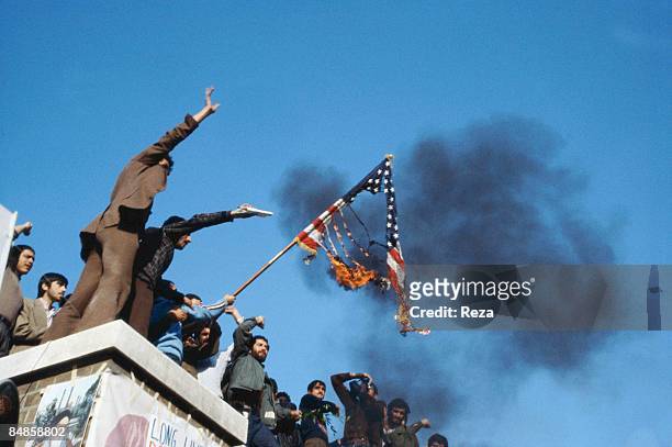 Group of hostage holders putting fire on the Amercian flag on the roof of the occupied U.S. Embassy during the U.S. Hostage crisis which was a...