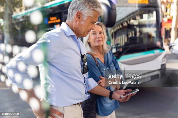 seniors at bus stop waiting to get to the airport - ile de france stock pictures, royalty-free photos & images