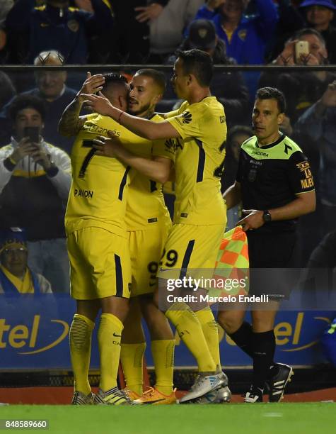 Cristian Pavon of Boca Juniors celebrates with teammates Dario Benedetto and Leonardo Jara after scoring the third goal of his team during a match...