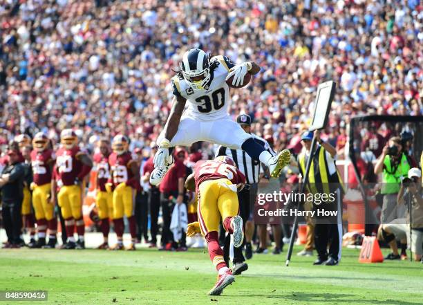 Todd Gurley of the Los Angeles Rams leaps over Bashaud Breeland of the Washington Redskins before scoring a touchdown during the third quarter at Los...