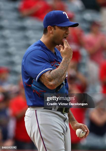 Pitcher Matt Bush of the Texas Rangers reacts after giving up a solo homerun to Mike Trout of the Los Angeles Angels of Anaheim during the eighthin...