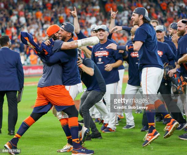 Jake Marisnick celebrates with George Springer and Josh Reddick after winning the American League West division at Minute Maid Park on September 17,...