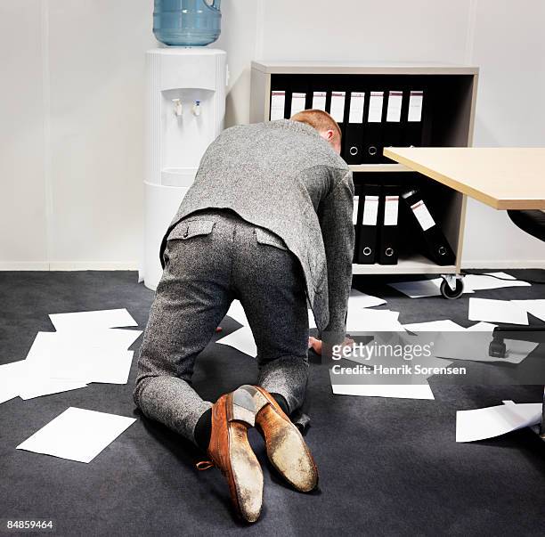 man picking up papers from the office floor. - 這う ストックフォトと画像