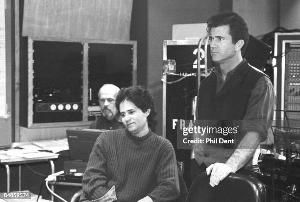 Photo of James HORNER and Mel GIBSON, composer, with sheet music at mixing desk while working on score to Braveheart film, with star Mel Gibson