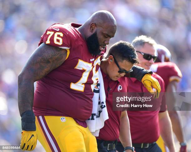 Morgan Moses of the Washington Redskins is helped off the field during the third quarter against the Los Angeles Rams at Los Angeles Memorial...